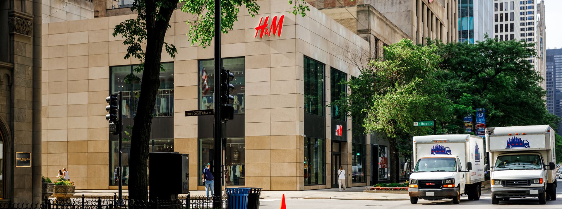 H&M store exterior with nearby delivery trucks.